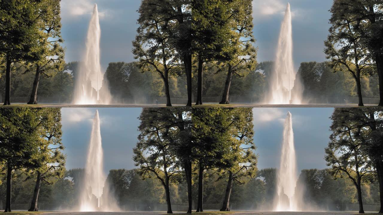 德国汉诺威。巨大的高喷水器从放在地上的碗中倒出。在公园绿树的背景下。泌尿外科男性疾病和前列腺炎的治疗