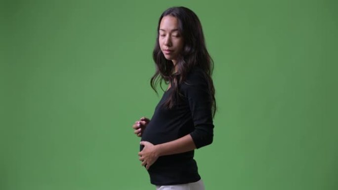 年轻怀孕的多种族妇女转身的后视图