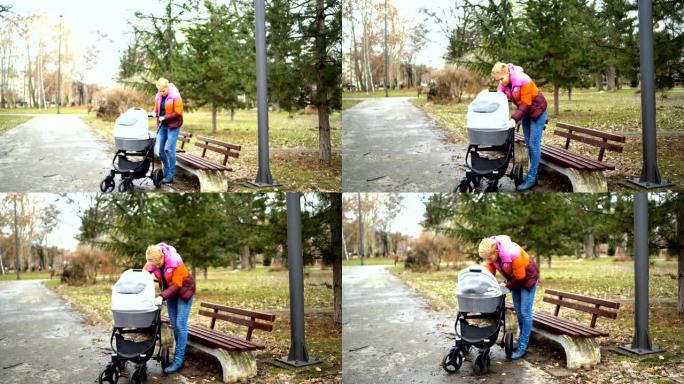 年轻的单身母亲和她的儿子，一个男孩，坐在轮椅上，照顾，关心。一个幸福的家庭。露天行走。母亲节，儿童保