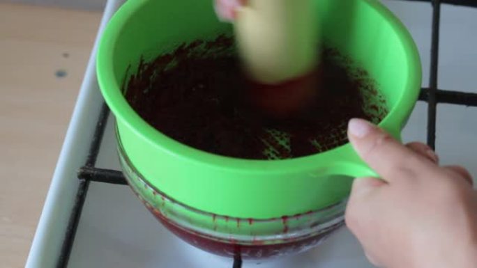 一名妇女在玻璃容器中的漏勺中磨制糖煮的蔓越莓。为棉花糖准备土豆泥。