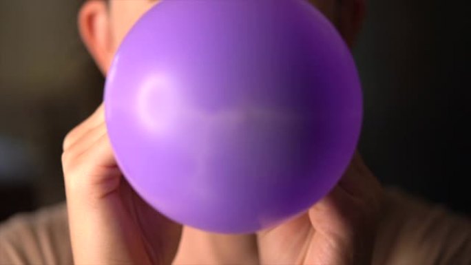 特写女人吹紫色气球慢动作