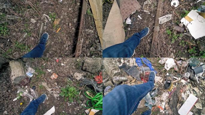 一个人的腿在户外用不同的垃圾穿过肮脏的地面。