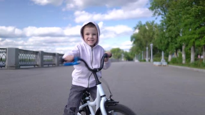 可爱的男孩孩子学习骑第一辆跑步平衡自行车