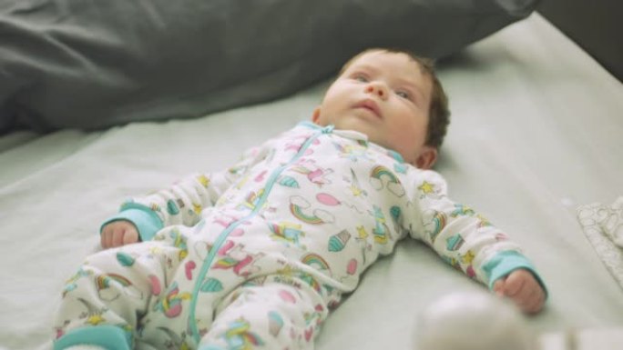 婴儿在婴儿监视器旁边的床上移动
