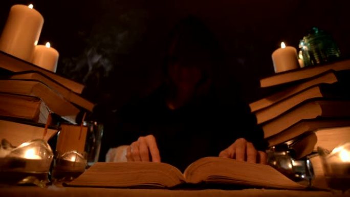 中等特写女孩魔术师在烛光下的黑暗房间里的兜帽里，寻找翻书的咒语。低调。