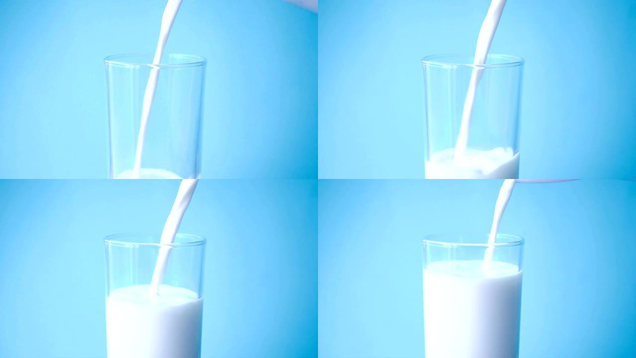 将新鲜牛奶倒入玻璃杯中，慢动作作用于蓝色背景，以促进健康，食物，饮用概念