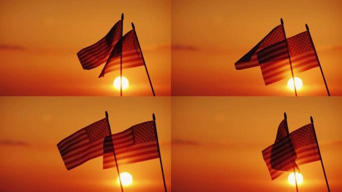 两面美国国旗映衬着夕阳和橙色的天空