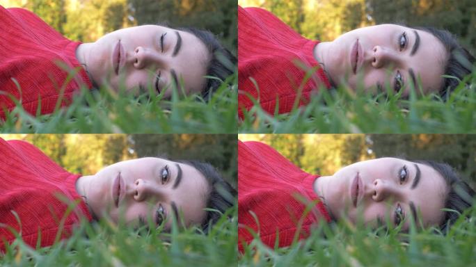 梦见美丽的年轻女子躺在草地上，睁开眼睛，看着相机