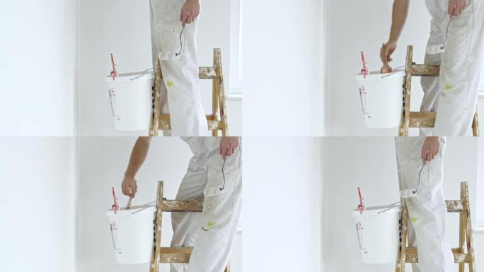 穿着白色工作服的男人站在梯子上粉刷墙壁