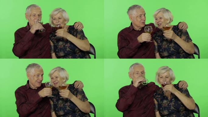 老年男子在色度键上与老年妇女同伴喝白葡萄酒