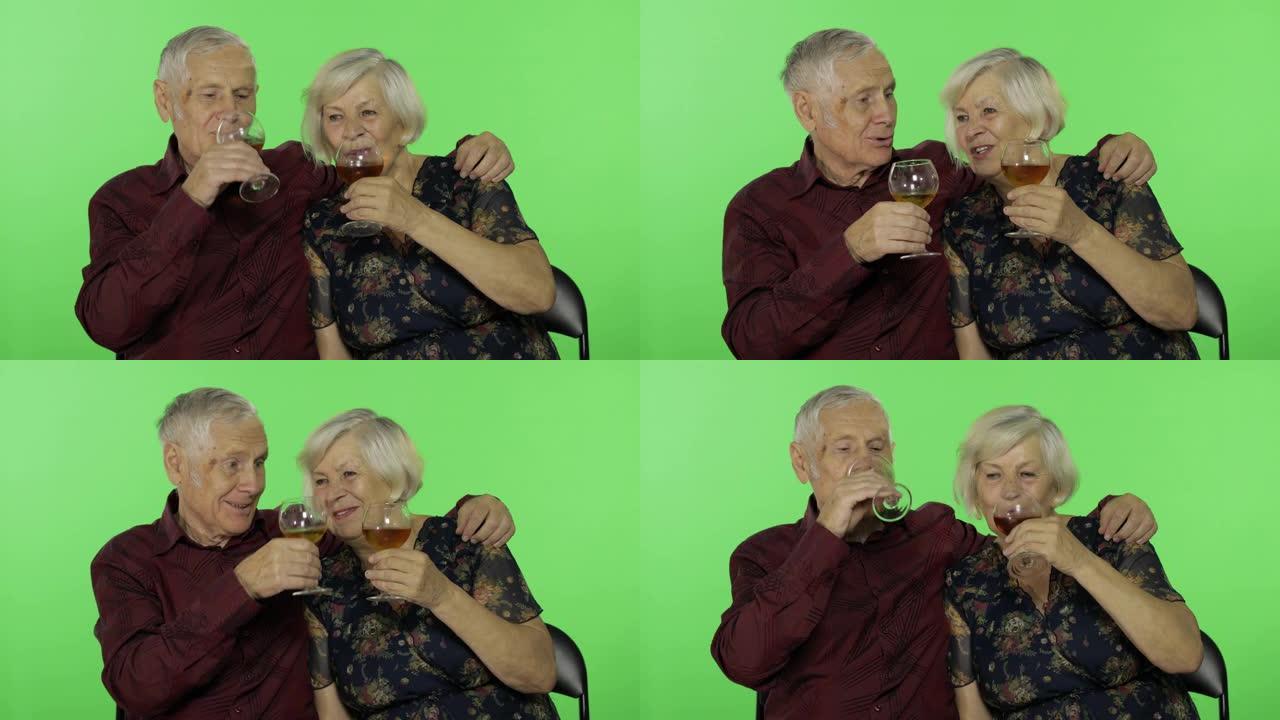 老年男子在色度键上与老年妇女同伴喝白葡萄酒