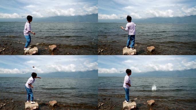 后视图小男孩站着向河边扔石头