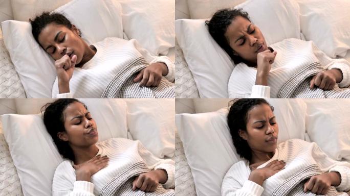 生病的年轻非洲妇女在床上睡觉时咳嗽的俯视图