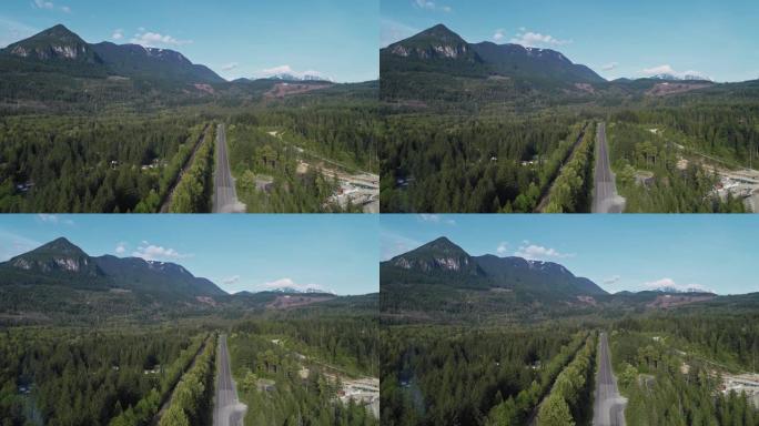 华盛顿州金条附近山区之间森林中繁忙的2号高速公路的鸟瞰图。无人机视频与下降的摄像机运动。