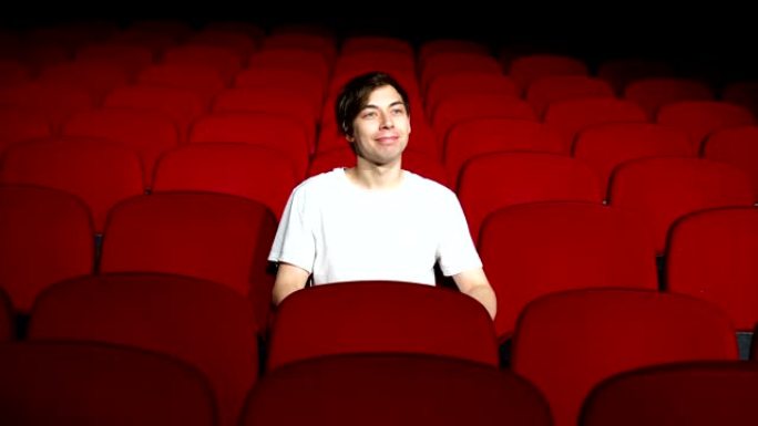 一个人独自坐在空荡荡的电影院或剧院里看表演或电影