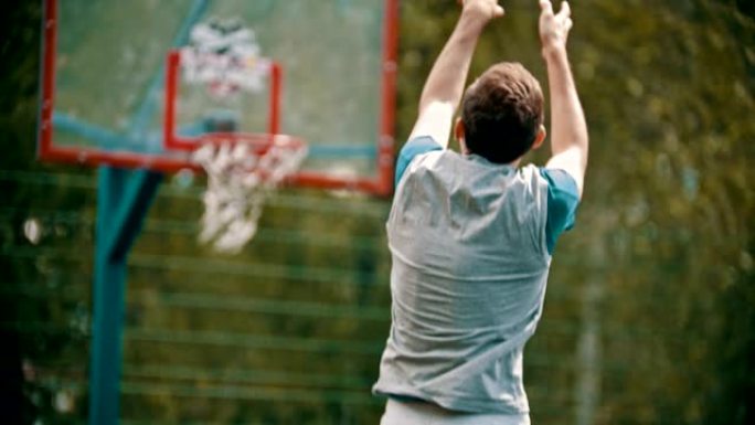 一名男子将球扔在篮球架上，错过了