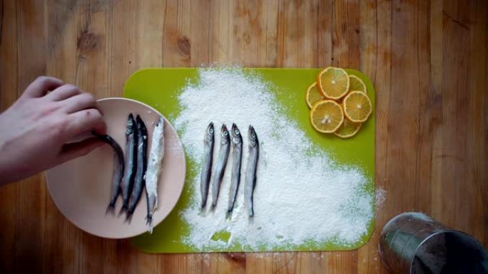 烹饪小鱼的过程，准备在煎锅中用油煎炸