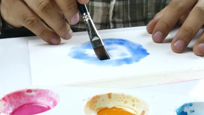 亚洲艺术家在白纸上手绘水彩