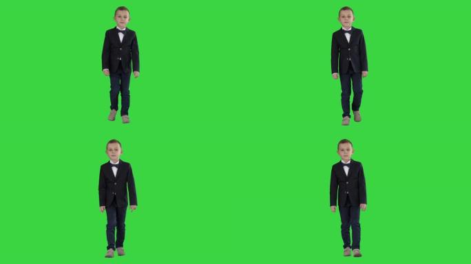 穿着领结服装的小男孩走在绿屏上，色键