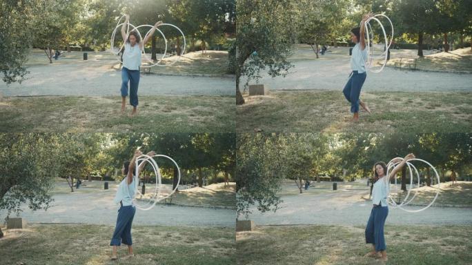年轻的成年妇女在公园里玩呼啦圈