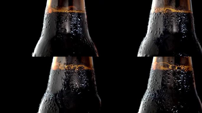 在黑色背景上拍摄一瓶冷黑啤酒的宏观旋转视频。