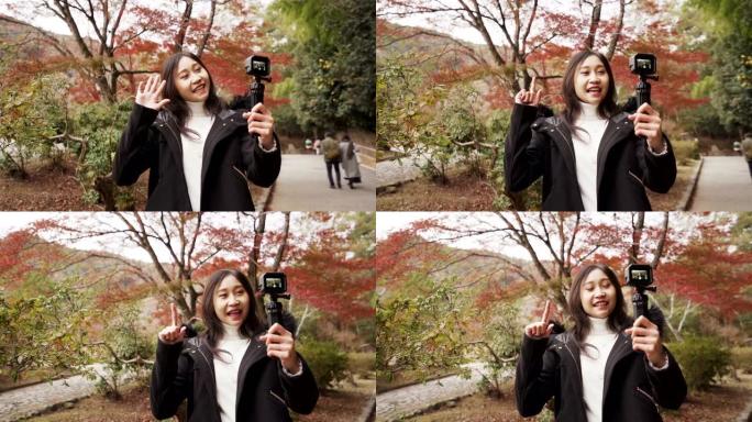 年轻的亚洲Youtuber在日本秋季假期与相机交谈