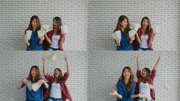 快乐两名年轻的亚洲女性拿着美钞兴奋而呕吐，人和商业金融