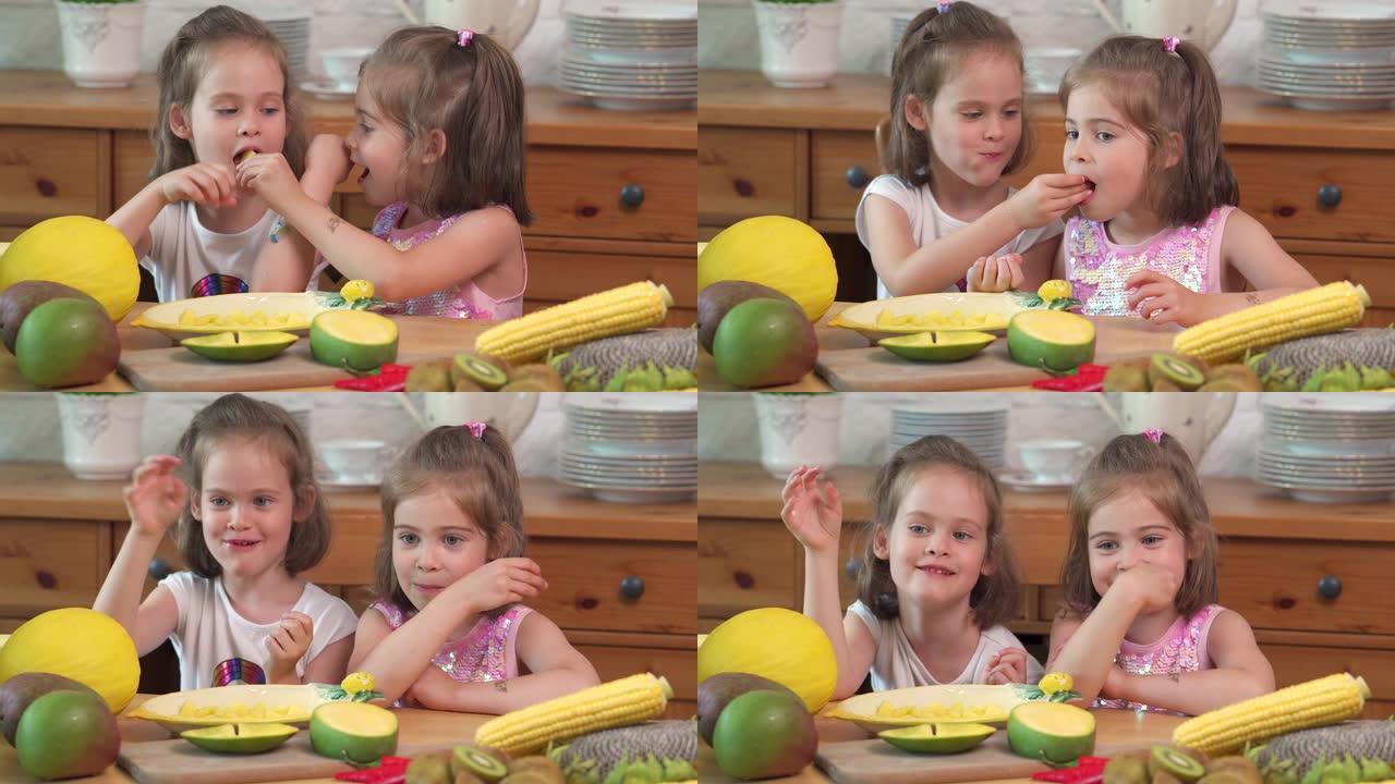 两个可爱的女孩在笑着吃多汁的黄色芒果