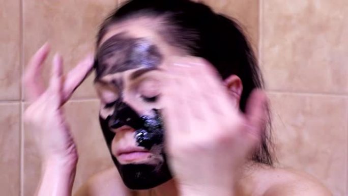 女人在脸上涂上黑色洁面霜面膜