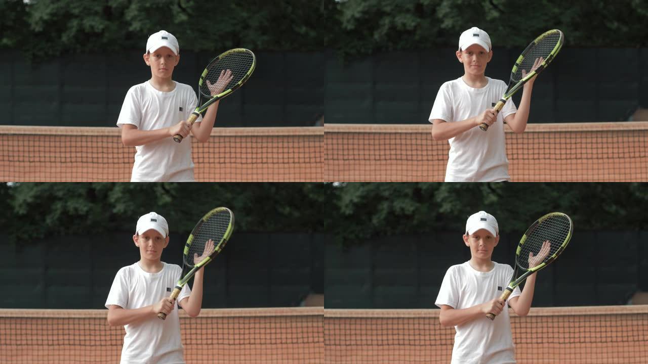 网球运动员少年男孩的肖像手握球拍，在球场上具有竞争精神
