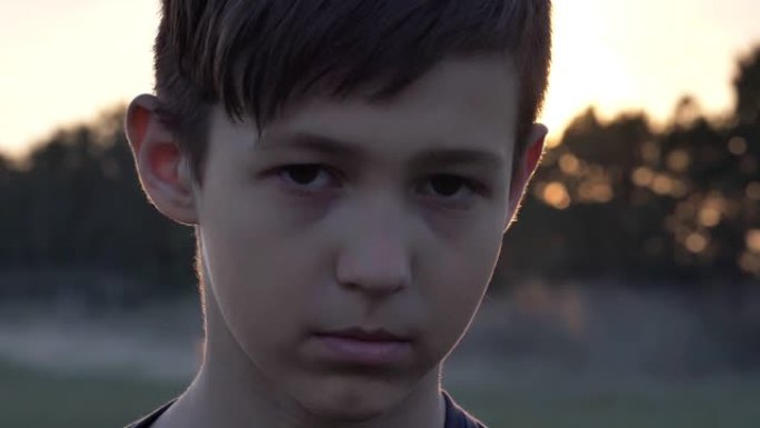 悲伤的男孩同情地看着镜头，无家可归的男孩，脸上的疼痛，特写