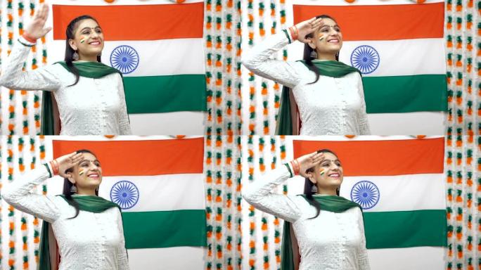 年轻的印度女孩仰望天空，向印度三色旗致敬，庆祝独立日