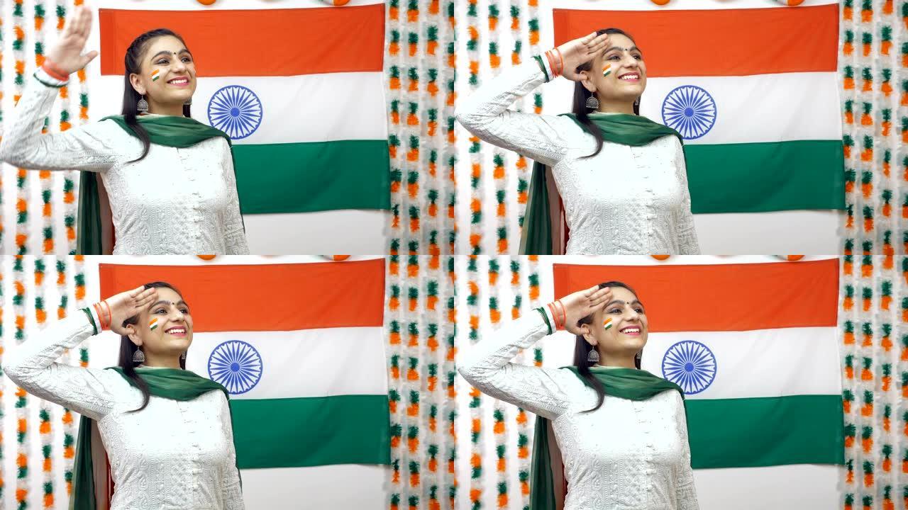 年轻的印度女孩仰望天空，向印度三色旗致敬，庆祝独立日