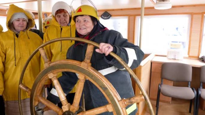 女船长在帆船的导航桥上转动方向盘。远海帆船的女水手掌舵。航海、航海和航运概念。