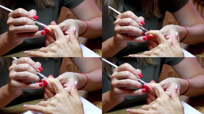 美甲大师用客户端食指指甲上的刷子创建渐变。特写视图。
