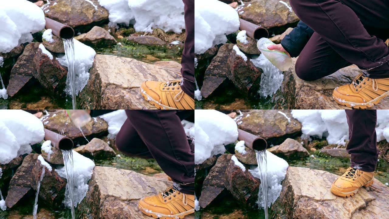 一位游客将山泉中的水倒入一个塑料瓶中。
