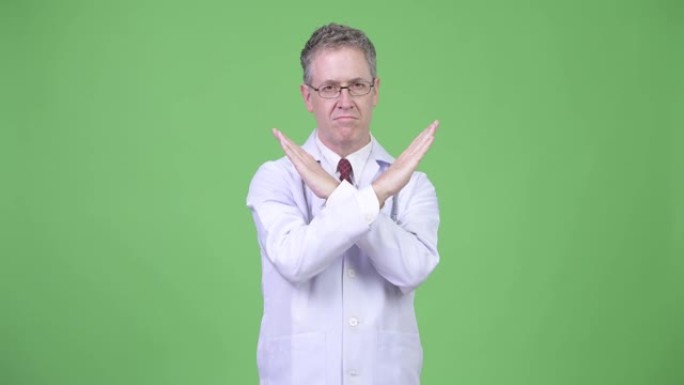 严肃的成熟男人医生，戴眼镜，用手臂显示停止手势
