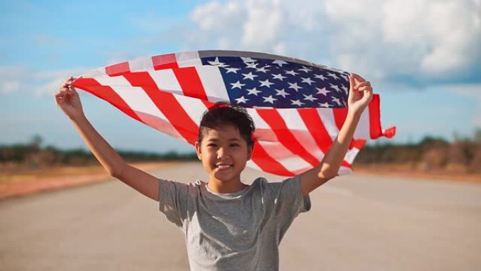 快乐的亚洲小女孩与美国国旗美国庆祝7月4日