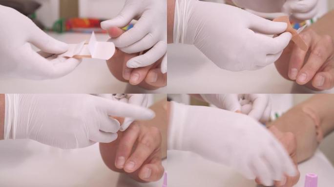 一名实验室技术人员戴着手套的特写演示，在采集血液样本后将医用膏药涂在患者的手指上。医疗保健概念。