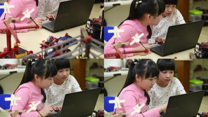 两个小女孩在笔记本电脑上共同编写机器人代码