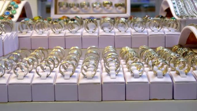 商店橱窗上有宝石和银制珠宝的各种银戒指