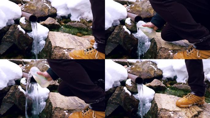 一位游客将山泉中的水倒入一个塑料瓶中。