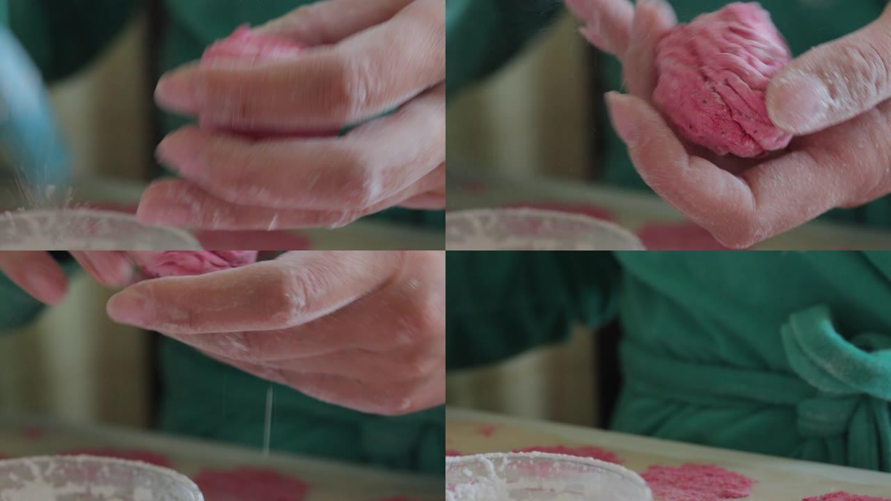 一名妇女用刷子将糖粉涂在棉花糖上。把它放在一边。特写。