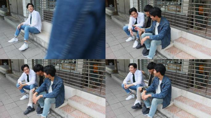 亚洲男子坐在街上等朋友