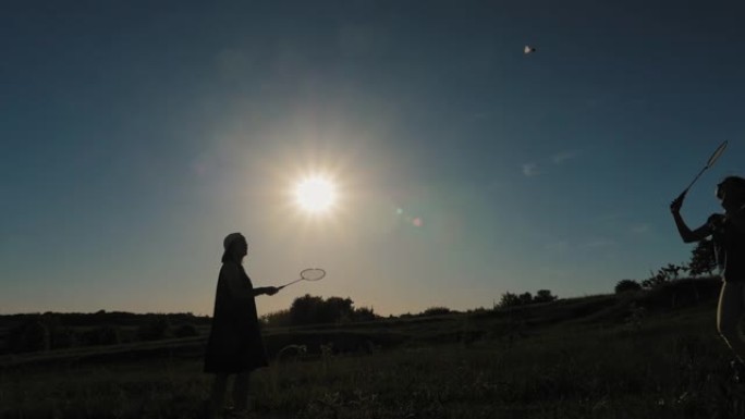 母女在日落背景下打羽毛球
