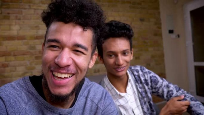 两名年轻的非洲裔美国人和印度男性博客的特写镜头在室内欢快地在摄像机上直播