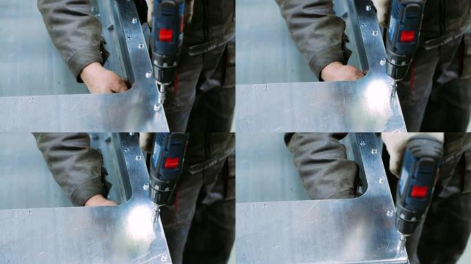 工人在拧紧金属块上的螺栓时使用带喷嘴的螺丝刀