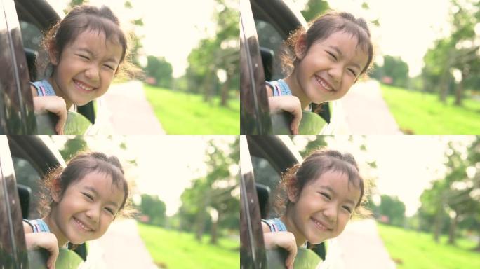快乐的亚洲女孩在车窗上玩耍，家庭在乡下旅行，慢动作拍摄