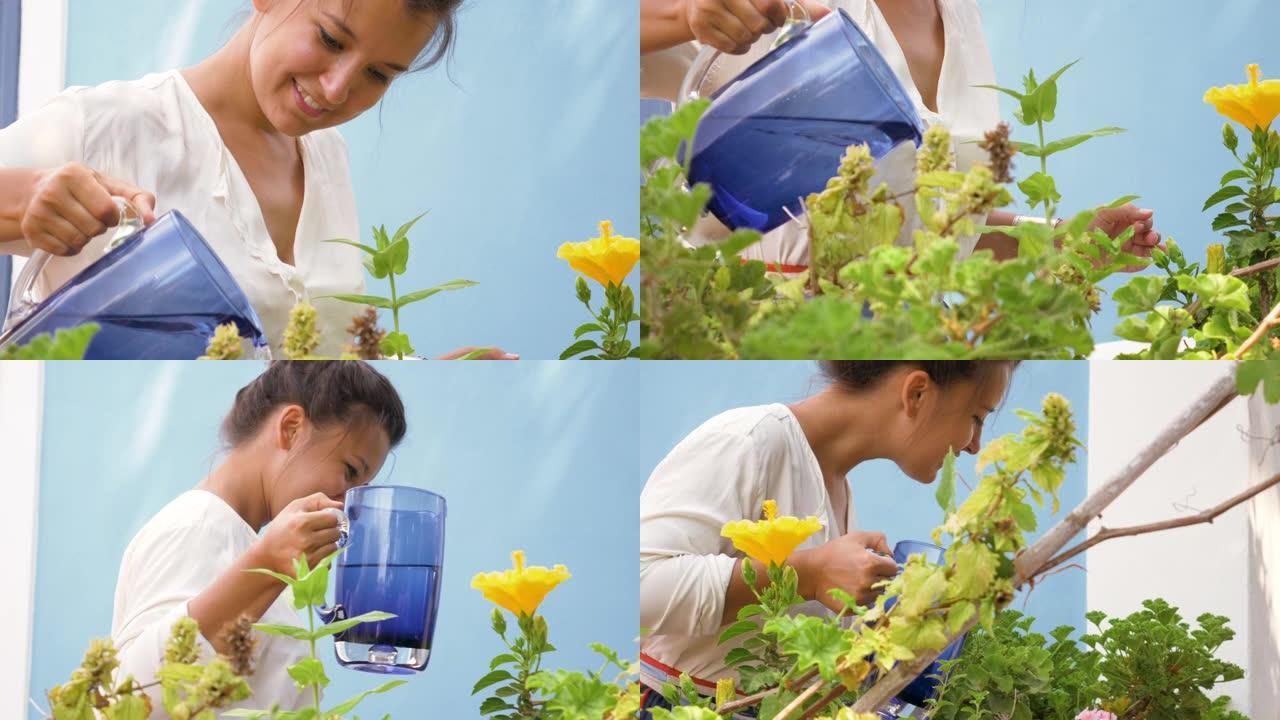 快乐的年轻女子在蓝色房子阳台上浇灌植物。时尚白衬衫和大帽子。意大利蓬扎岛。