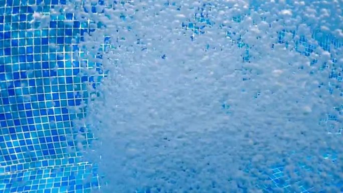 水池中清澈蓝色水中的气泡 (水下拍摄)，适合背景，慢动作
